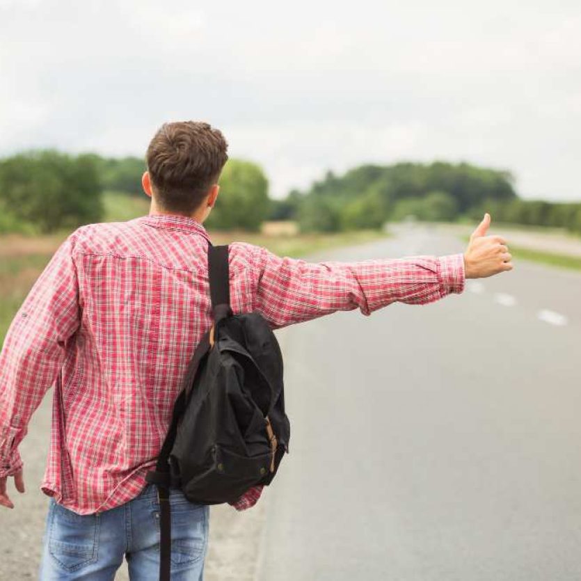 rear-view-young-man-with-his-backpack-hitchhiking-straight-road_11zon